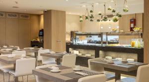 a restaurant with tables and chairs and a counter at Ilunion Auditori in Barcelona