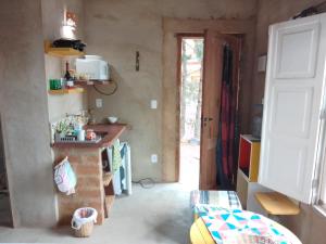 uma cozinha com uma porta aberta para um quarto em Chalé Caiçara em Carrancas