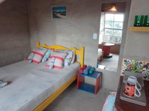 カランカスにあるChalé Caiçaraのベッドルーム1室(大型ベッド1台、カラフルな枕付)
