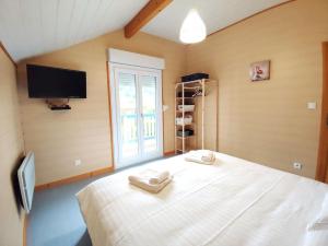 a bedroom with a bed with two towels on it at Le Vivaldi, Au cœur du massif vosgien avec terrain de pétanque in Rochesson