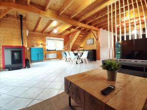 a large living room with a table and chairs at Le Vivaldi, Au cœur du massif vosgien avec terrain de pétanque in Rochesson