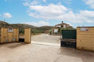 an empty parking lot with a gate and a house at Apartamento LLanos de belen in Ardales