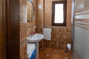 a bathroom with a sink and a toilet and a mirror at Apartamento LLanos de belen in Ardales