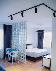 um quarto com uma cama, uma mesa e um ecrã. em Kazbegi Apartments em Stepantsminda