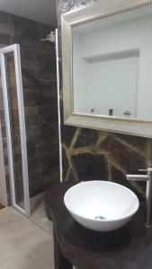 y baño con lavabo blanco y espejo. en Hotel Chalet Casa Grande, en Nobsa