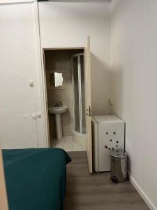 a small bathroom with a sink and a refrigerator at IRU, not for parties, not a hotel, room with no kitchen in Amsterdam