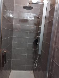 La salle de bains est pourvue d'une douche avec une porte en verre. dans l'établissement La Cordonnerie de Las Places, à Campagne-dʼArmagnac