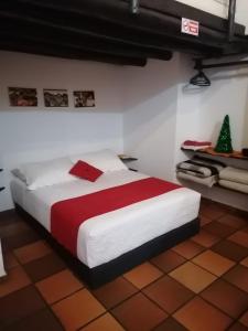 een slaapkamer met een bed met een rode en witte deken bij Hotel Chalet Casa Grande in Nobsa
