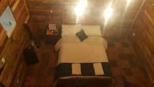 een kleine slaapkamer met een bed met witte lakens en kussens bij Hotel Chalet Casa Grande in Nobsa