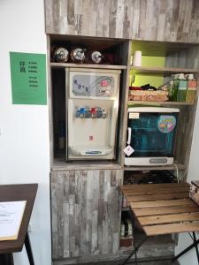 einem Kühlschrank mit Tür neben einem Tisch in der Unterkunft 漫步山嵐 A walk in the mist in Lugu