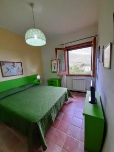 um quarto com uma cama verde e uma janela em Il Baglio di donna Rosa em Custonaci