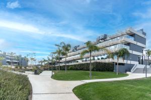 un grand immeuble avec des palmiers et un trottoir dans l'établissement Oasis 325 Ground Floor, à Estepona