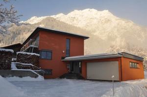 une maison avec un garage en face d'une montagne dans l'établissement Ammann Marika, à Vandans