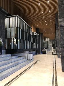 a lobby with stairs and a large building with windows at APARTMENT SPRINGWOOD RESIDENCE by HW APARTMENT in Warungmangga