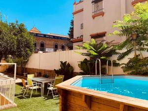 - une piscine dans une cour avec une table et des chaises dans l'établissement Palacete del Porvenir, à Séville