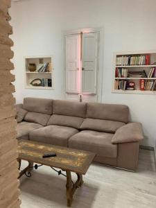 Palacete del Porvenir في إشبيلية: غرفة معيشة مع أريكة وطاولة قهوة