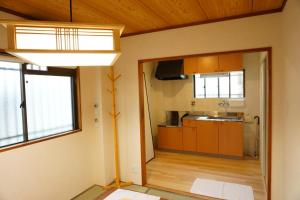 a kitchen with wooden cabinets and a large window at SYOGA A house, next to natural park in Osaka