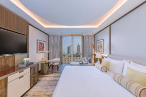 Mandarin Oriental Al Faisaliah, Riyadh في الرياض: غرفة فندقية بسرير كبير وتلفزيون بشاشة مسطحة
