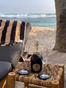 a bottle of wine and two glasses on a table at Harding Boutique Hotel in Ahangama