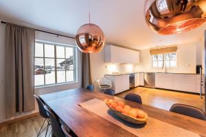 a kitchen and dining room with a wooden table with oranges on it at Ramundberget Skarsgården in Bruksvallarna