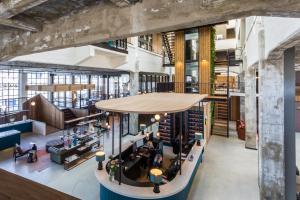 an overhead view of a library with people sitting in chairs and tables at Hotel de Timmerfabriek I Kloeg Collection in Vlissingen