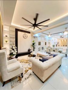 uma sala de estar com um sofá e uma ventoinha de tecto em FARIDZ Homestay at Myra Saujana em Kampong Simpang Empat