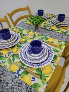 a table with plates and cups on a table with lemons at Atlântico Flat Natal in Natal
