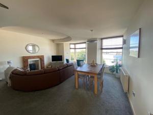 a living room with a couch and a table at Caldey View- a beautiful flat in the heart ofTenby in Tenby +6 photos