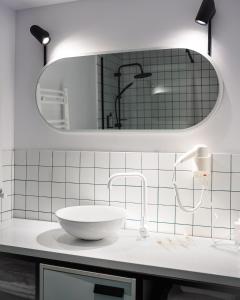 a white bathroom with a sink and a mirror at Kazbegi Apartments in Stepantsminda