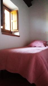 ein Schlafzimmer mit einem Bett mit einer roten Decke und einem Fenster in der Unterkunft Logement avec parking et terrasse devant la maison, très jolie vue in Pettorano sul Gizio