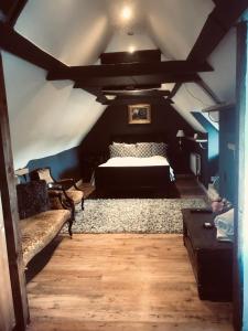 Tudor House - Double Room - Shared Bathroom في Goffs Oak: غرفة نوم بسرير كبير في العلية