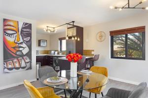a dining room and kitchen with a glass table and chairs at Knightsbridge Terrace in Cape Town +32 photos