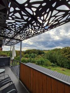 a balcony with a black metal roof with a view at Aura Lux Holiday Home with Pool in Lopatinec