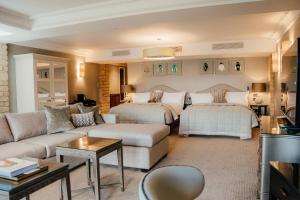 - un salon avec deux lits et un canapé dans l'établissement Pennyhill Park Hotel and Spa, à Bagshot