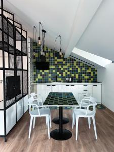 a kitchen with a table and white chairs at Kazbegi Apartments in Stepantsminda