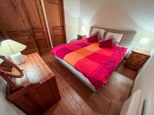 a bedroom with a large bed with a colorful blanket at Chalet l'Arnica in Les Gets