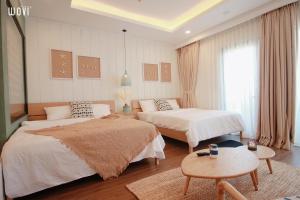 a hotel room with two beds and a table at FLC SEA TOWER - 4 SEASONS Apartment in Quy Nhon