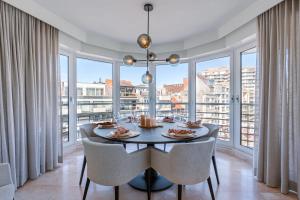 comedor con mesa y ventanas grandes en Bright and spacious apartment with stunning views!, en Knokke-Heist