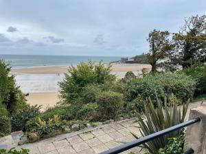 a view of a beach with a pier in the distance at Newton Croft Tenby overlooking North Beach in Tenby