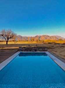 a swimming pool in the middle of a desert with mountains at Encuentro de Almas (Soulmate Encounter) in Tinogasta