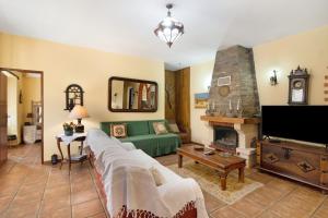 a living room with a green couch and a fireplace at Casa Rústica in Silves