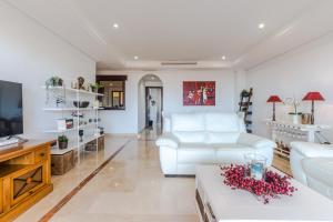 un soggiorno con divano bianco e TV di El Soto de Marbella a Marbella