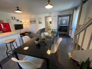 een woonkamer met een tafel en witte stoelen bij Résidence Tamaris Soline in Lanvallay