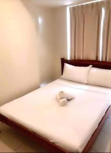 a teddy bear sitting on top of a bed at Affordable Tagaytay Monteluce 1 BR WITH POOL-224 in Lalaan Primero