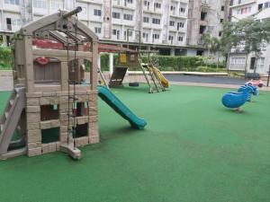 a playground with a slide and a play structure at Affordable Tagaytay Monteluce 1 BR WITH POOL in Lalaan Primero