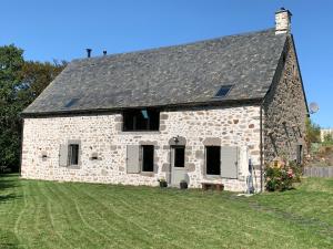 an old stone house with a green yard at La Grange De L’Abille in Marchastel