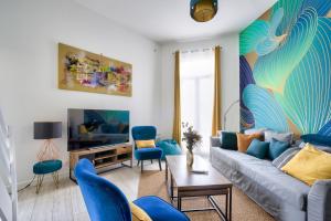 a living room with a couch and blue chairs at Bordeaux : superb apartment near St-Jean station in Bordeaux