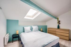 a bedroom with a white bed and a skylight at Bordeaux : superb apartment near St-Jean station in Bordeaux