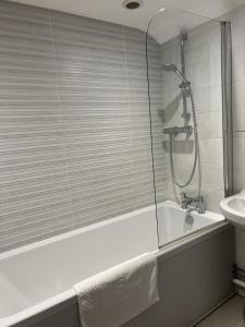 a bathroom with a shower and a tub and a sink at John Barleycorn in Duxford