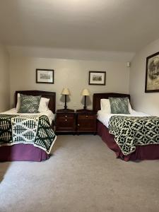 um quarto com duas camas e dois candeeiros em John Barleycorn em Duxford